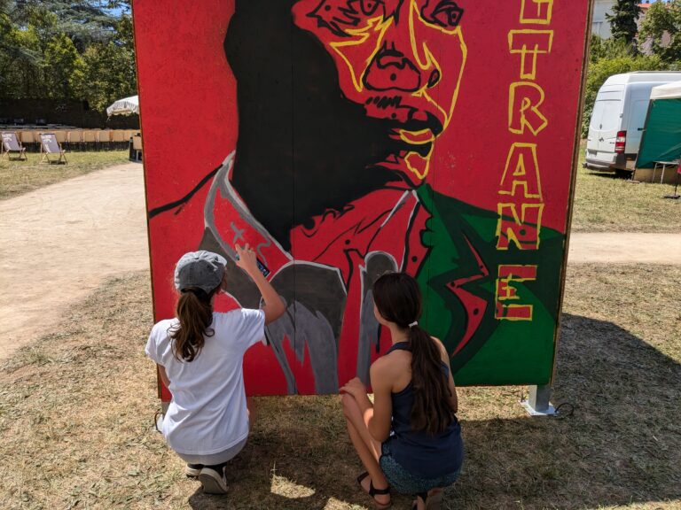 Des jeunes en atelier de graf au Millau Jazz Festival. Le visage reproduit est celui de John Coltrane.